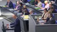 Bundestag, Olaf Scholz mit gelber EILT-Mappe bei der Generaldebatte am 11.12.2024 im Vordergrund ist auch Friedrich Merz (CDU) zu sehen.