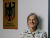 Dorothea Störr-Ritter neben dem Schild des Nationalen Normenkontrollrats in Berlin